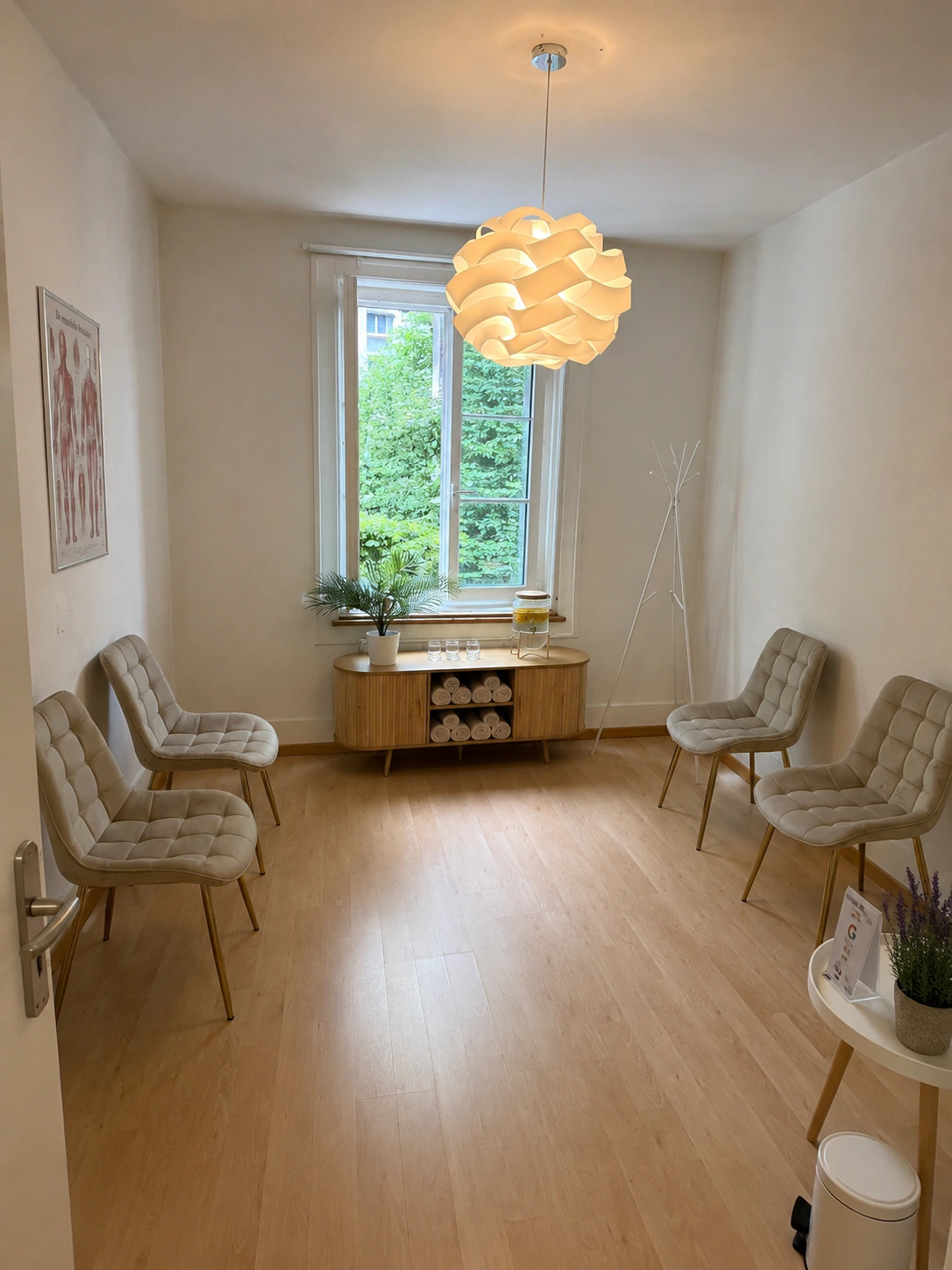 Wartebereich des Massage Zentrum Spiez mit vier Sesseln und Sideboard am Fenster